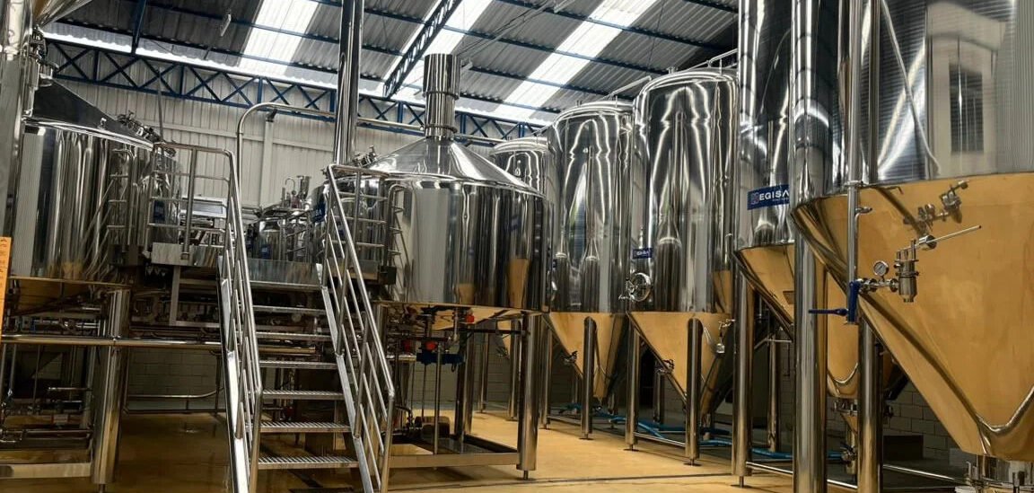 Sala de brassagem da Ravache: tanques, escada de acesso e clarabóias