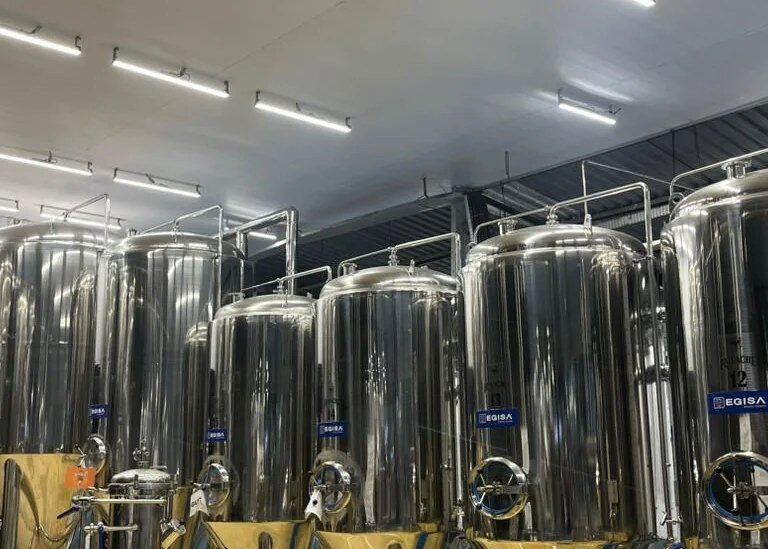 Corredor de fermentadores da Cervejaria Ravache em fuga de perspectiva
